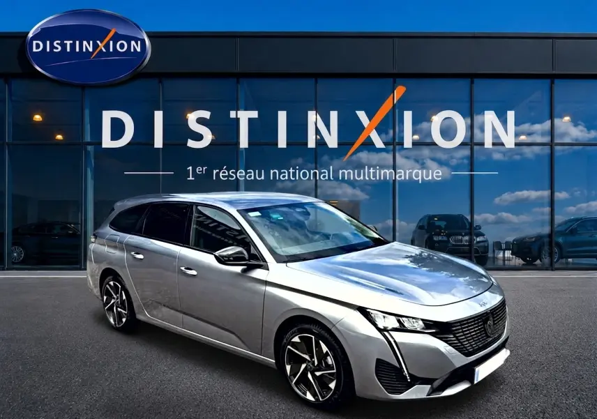 Peugeot 308 SW gris vue 3/4 avant droit, jantes alliage et vitres arrière surteintées devant showroom Distinxion.