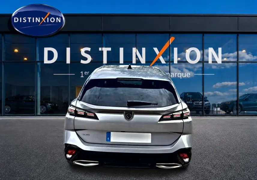 Vue arrière d'une Peugeot 308 SW gris métallisé 2025, avec feux LED distinctifs et double sortie d'échappement.