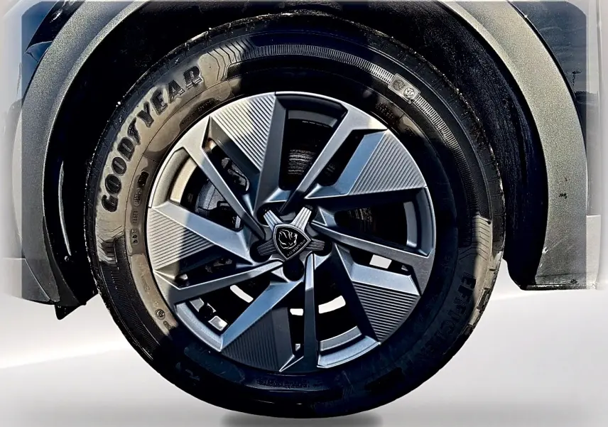 Gros plan sur la roue avant droite d'une Peugeot 408 Hybrid 145 allure e-dcs6 noire, jante alu au design moderne.
