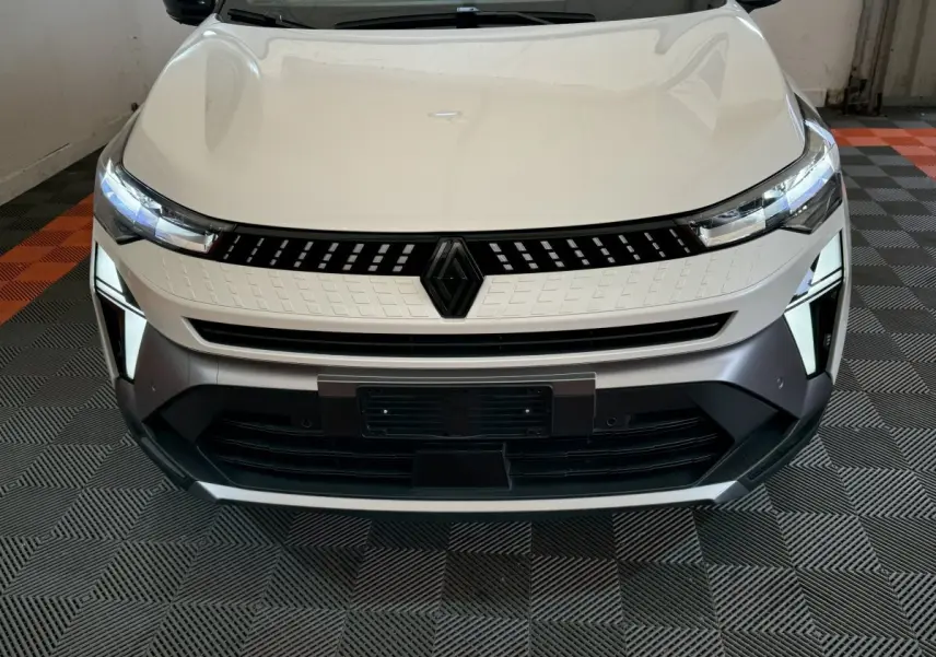 Vue frontale rapprochée du Renault Captur blanc esprit Alpine E-Tech 2025 avec calandre et phares LED allumés.