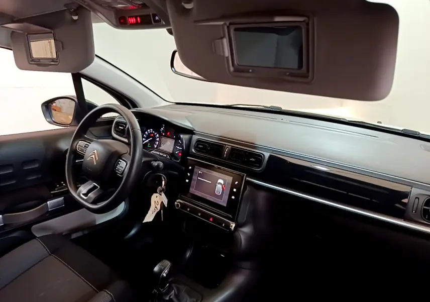 Vue intérieure côté conducteur de la Citroën C3 2019 avec tableau de bord noir et écran tactile central allumé.