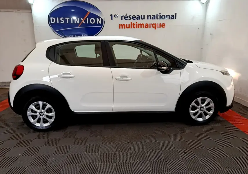 Profil côté gauche d'une Citroën C3 blanche 2019 avec jantes alliage et protections noires sur les passages de roue.