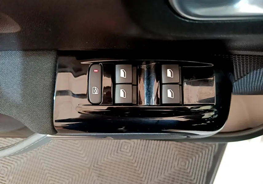 Gros plan sur les commandes des vitres électriques côté conducteur d'une Citroën C3 blanche, finition Feel Business.