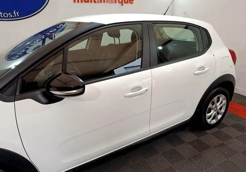 Profil côté gauche d'une Citroën C3 blanche 2019 avec rétroviseur noir et poignées de porte assorties.