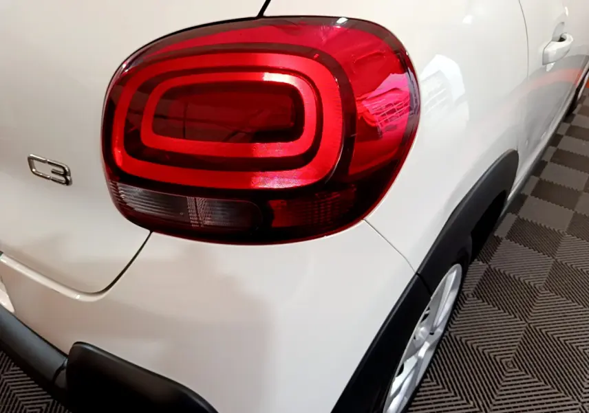Gros plan sur le feu arrière droit d'une Citroën C3 blanche de 2019, avec logo C3 visible sur la carrosserie.