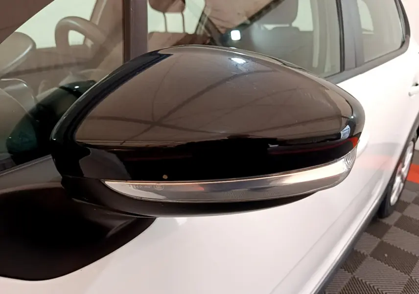 Rétroviseur noir avec clignotant intégré côté gauche d'une Citroën C3 blanche vue en gros plan.