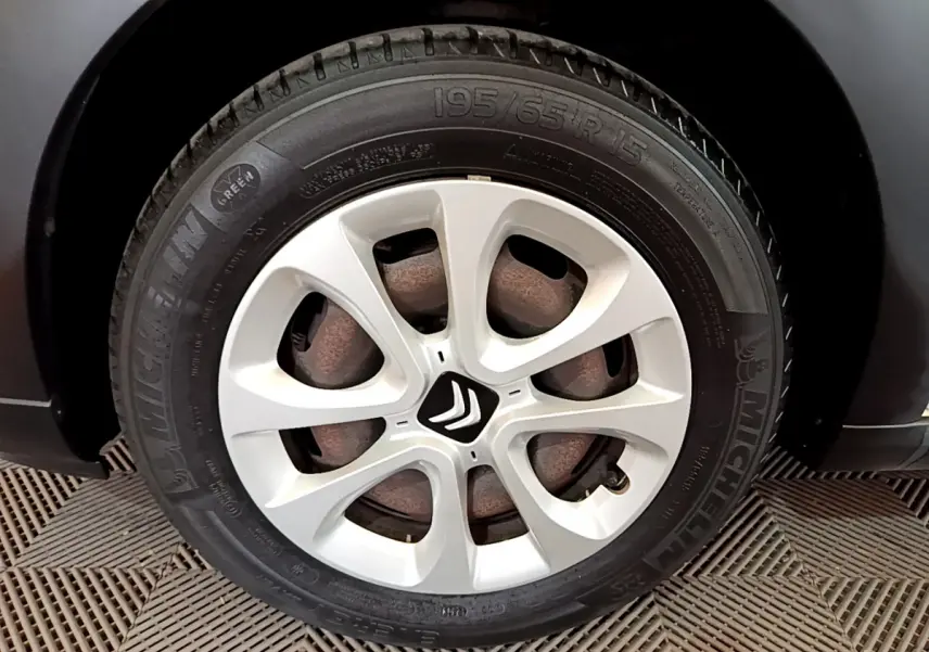 Gros plan sur la roue avant droite d'une Citroën C3 blanche, mettant en valeur la jante et le logo Citroën central.