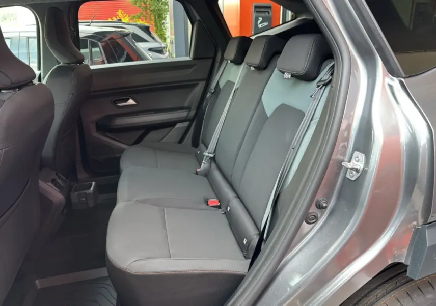 Vue côté droit sur la banquette arrière grise du Dacia Bigster Hybrid 155 Extreme Plus avec porte ouverte.