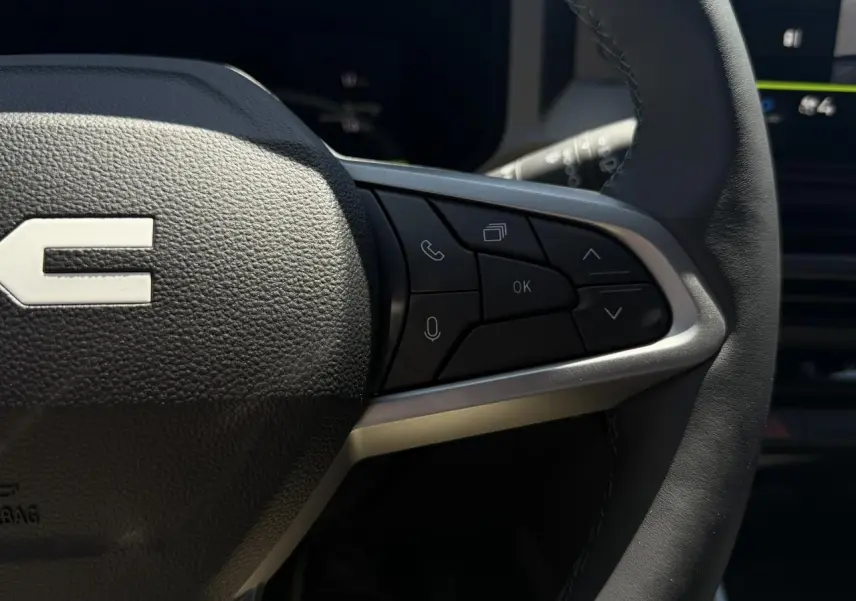 Gros plan sur le côté droit du volant noir du Dacia Bigster 2026, avec commandes multifonctions intégrées.