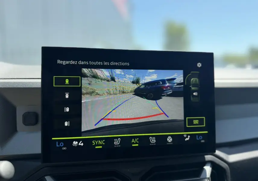 Écran tactile intérieur montrant la caméra de recul du Dacia Bigster Hybrid-G 150 4X4 en bleu indigo.