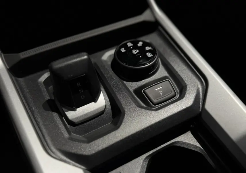Gros plan sur la console centrale noire du Dacia Bigster 2026, montrant le levier de vitesses automatique et la molette de sélection 4x4.