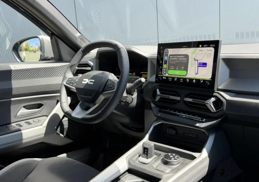 Vue intérieure côté conducteur du Dacia Bigster 2026, montrant le volant, écran tactile et console centrale moderne.