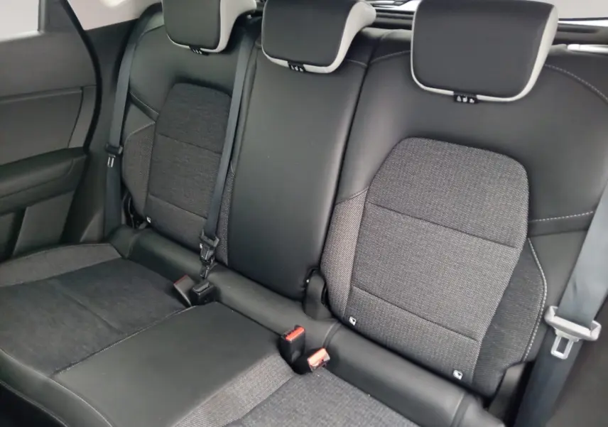 Vue rapprochée des sièges arrière en tissu gris et cuir noir du Renault Captur 2023, avec ceintures de sécurité visibles.