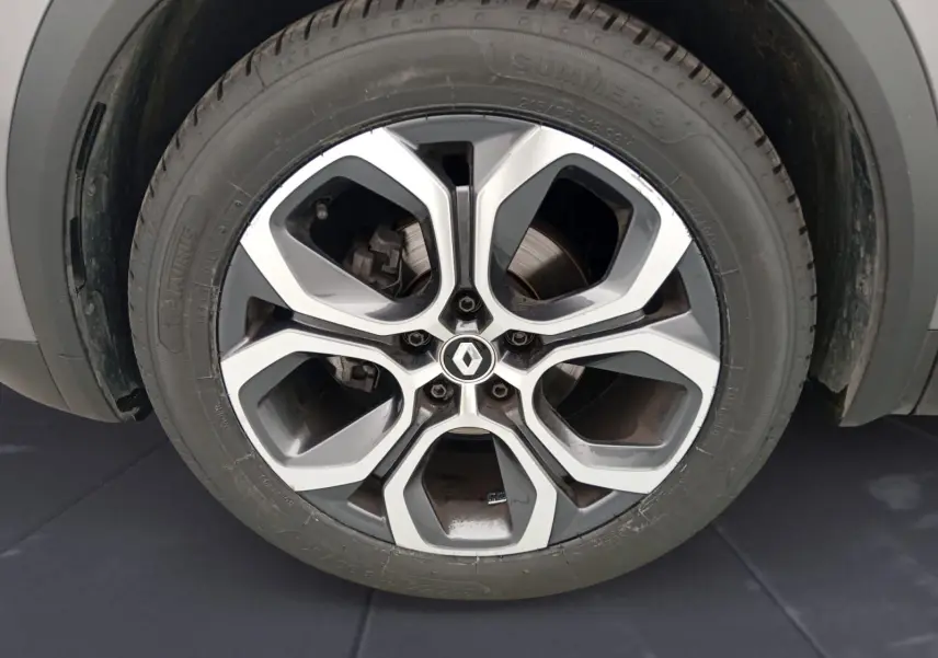 Gros plan sur la roue arrière gauche du Renault Captur gris Cassiopée/ noir, soulignant l'architecture de l'aile et le pneu.