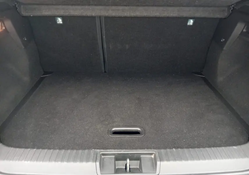 Vue intérieure du coffre vide du Renault Captur 1.3 Mild Hybrid 140 Techno, revêtement noir uniforme.