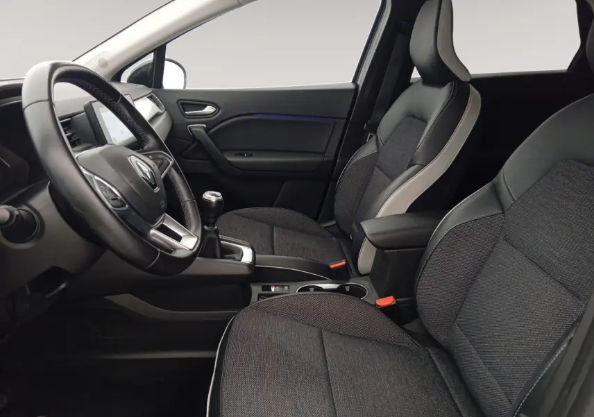 Vue intérieure côté conducteur du Renault Captur 1.3 Mild Hybrid 140 Techno avec sièges tissu gris et cuir noir, volant multifonction.