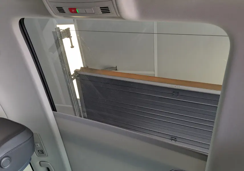 Vue intérieure sur la vitre latérale droite du Volkswagen Tiguan noir, avec partie du siège et garniture visibles.