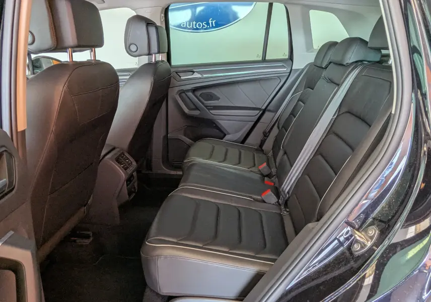 Vue intérieure côté droit des sièges arrière en cuir noir du Volkswagen Tiguan 2021 avec ceinture de sécurité grise.