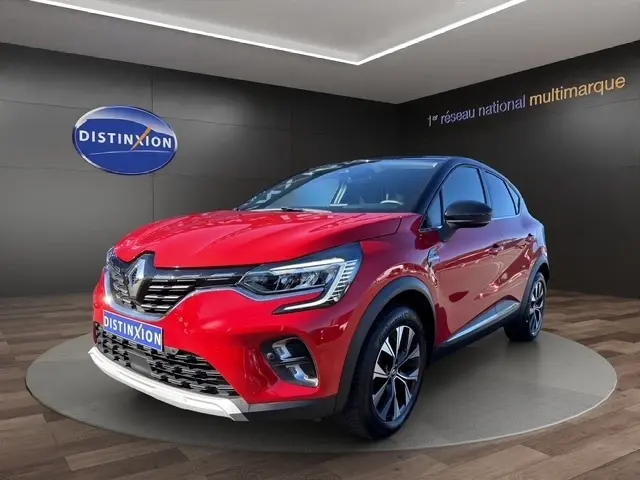 Renault Captur Techno TCe 90 rouge en 3/4 avant droit, avec jantes alliage et calandre chromée visible.