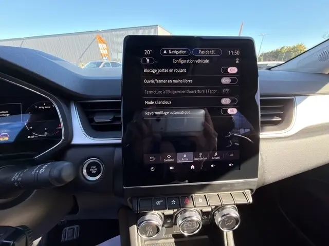 Vue rapprochée de la console centrale tactile du Renault Captur 2024, affichant les réglages de verrouillage et climatisation.