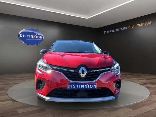 Vue avant d'un Renault Captur Techno TCe 90 rouge vif, avec calandre noire et logo Renault bien visible.
