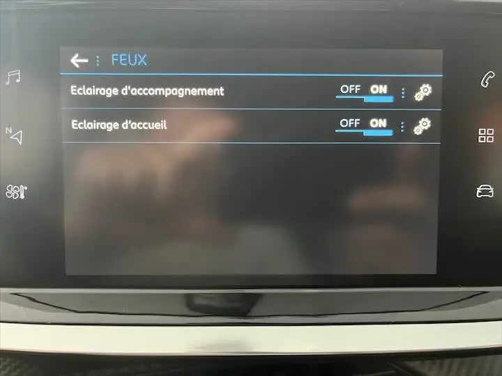 Écran tactile intérieur de la Peugeot 208 affichant les réglages d'éclairage d'accompagnement et d'accueil.