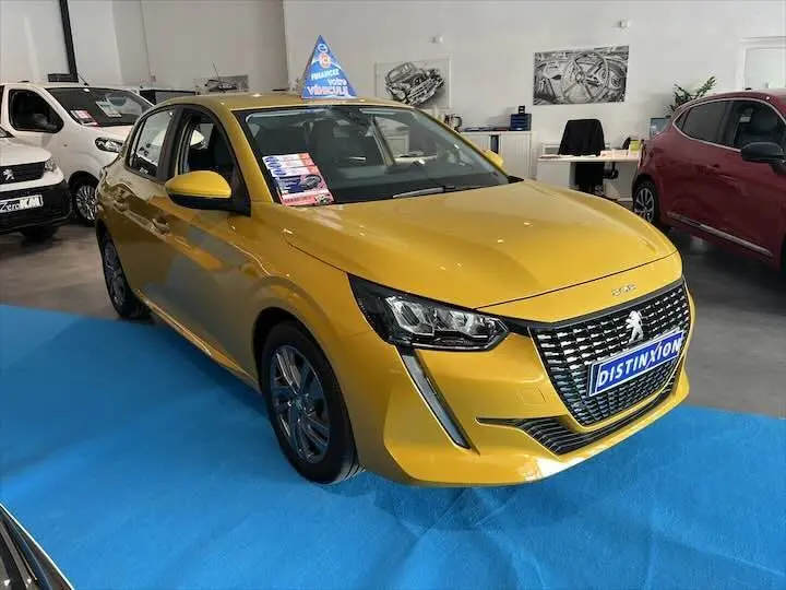 Peugeot 208 jaune Faro métal vue 3/4 avant droit en showroom avec plaque Distinxion visible.