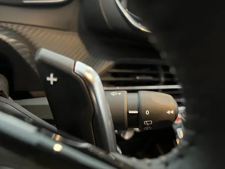 Gros plan sur la commande de clignotant et la palette de changement de vitesse côté droit du Peugeot 208 jaune Faro Metal.