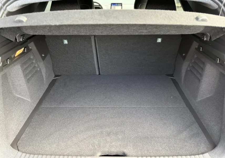 Coffre ouvert vu de l'arrière d'une Renault SYMBIOZ gris Rafale, montrant un espace de chargement propre et spacieux.