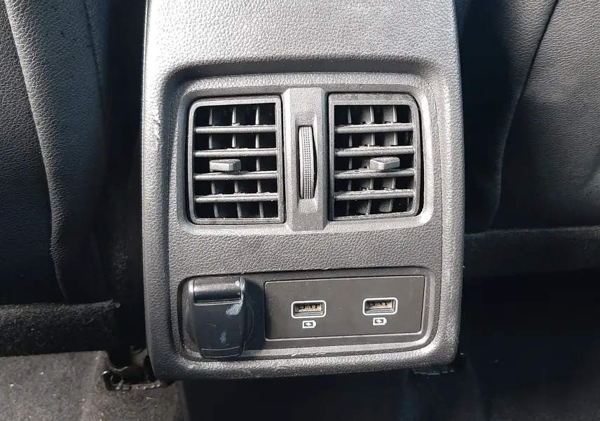 Gros plan sur la console arrière noire du Renault Captur 2020, avec deux bouches d'aération et deux ports USB visibles.