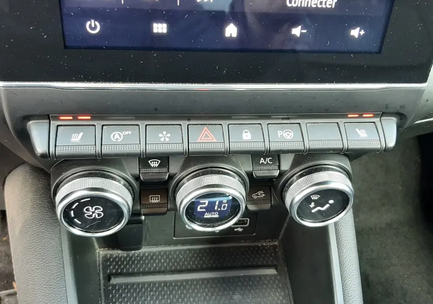 Gros plan sur la console centrale du Renault Captur 2020, montrant les commandes de climatisation et les boutons de fonction.