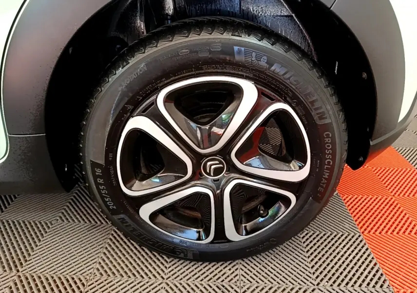 Gros plan sur la roue avant droite de la Citroën C3 PureTech 82 S&S BVM Graphic verte avec jante alliage noire et argentée