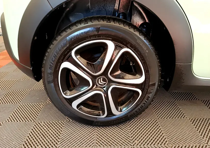 Gros plan sur la roue avant gauche de la Citroën C3 vert clair, mettant en valeur la jante alliage au design moderne.