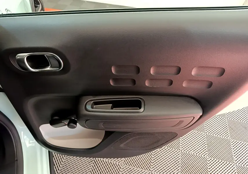 Gros plan sur la porte intérieure côté gauche de la Citroën C3 PureTech 82 S&S BVM Graphic, avec poignée noire et panneau texturé.