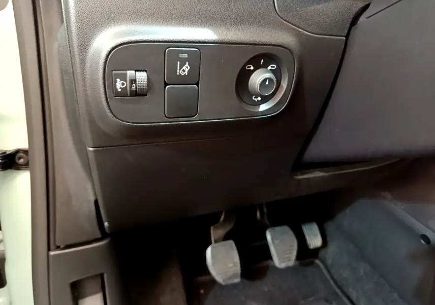 Détail des commandes d'éclairage et réglage des rétroviseurs côté gauche dans l'habitacle noir d'une Citroën C3 verte.
