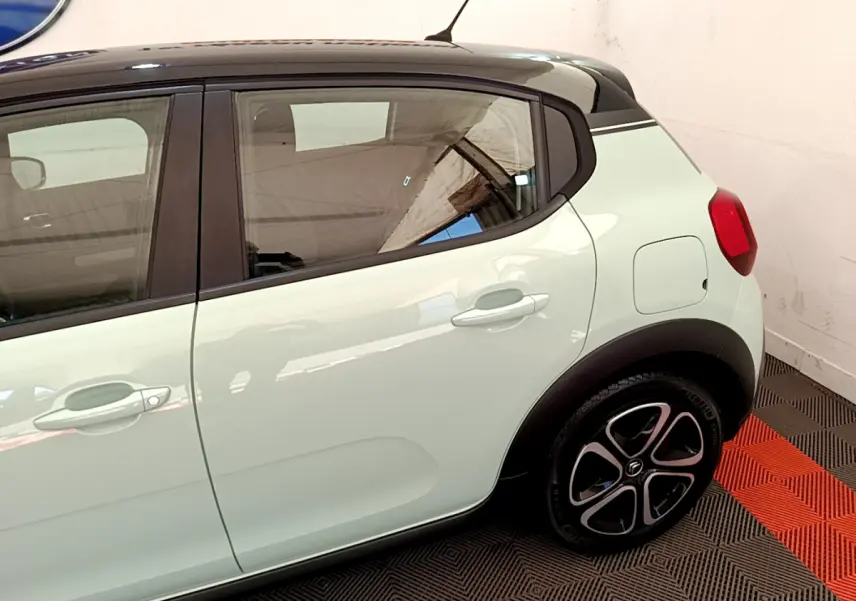 Vue latérale droite d'une Citroën C3 PureTech 82 vert clair avec toit noir et jantes stylisées.