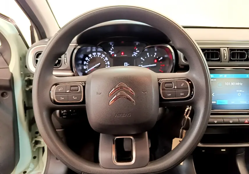 Vue rapprochée du volant multifonctions noir d'une Citroën C3 2019 avec tableau de bord et écran tactile visible.