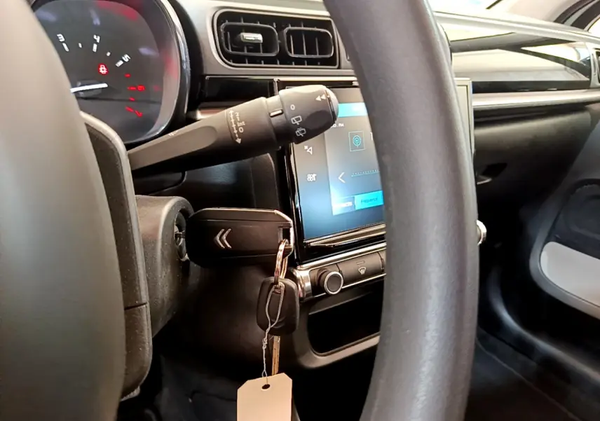 Vue intérieure centrée sur le volant et l'écran tactile de la Citroën C3 PureTech 82, avec clé insérée au contacteur.