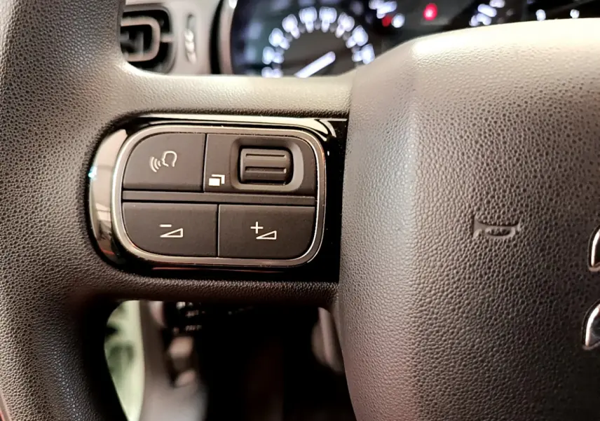 Gros plan sur les commandes gauche du volant noir du Citroën C3 PureTech 82 S&S BVM Graphic 2019.