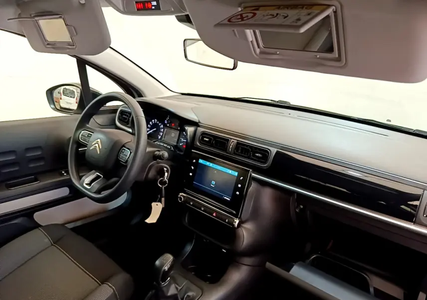 Intérieur de la Citroën C3 PureTech 82 vert, vue côté conducteur montrant tableau de bord et écran tactile central.