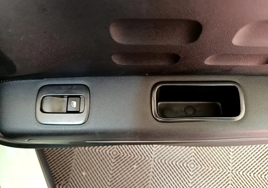 Gros plan sur la poignée intérieure et le bouton de verrouillage de la porte côté gauche d'une Citroën C3 verte.