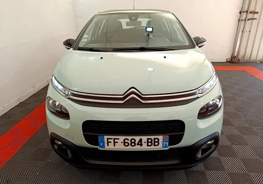 Vue avant d'une Citroën C3 PureTech 82 vert clair avec phares LED et calandre noire dans un garage.