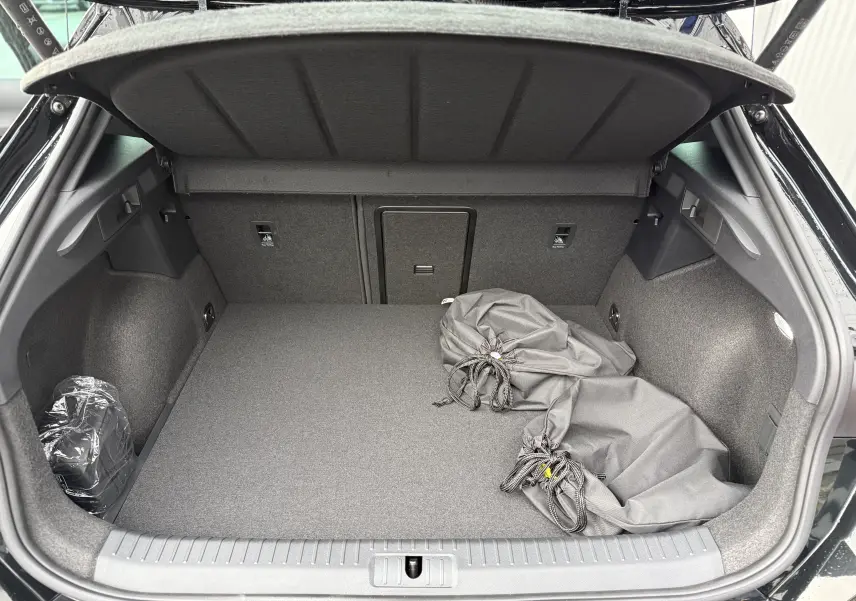 Coffre ouvert d’une CUPRA Formentor noir minuit 2025, vue arrière montrant un espace de chargement propre avec housses grises.