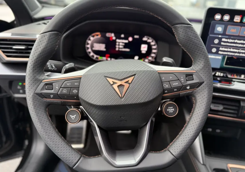 Vue rapprochée du volant perforé noir avec surpiqûres cuivrées et logo CUPRA cuivré du Formentor 1.5 eHybrid 2025.