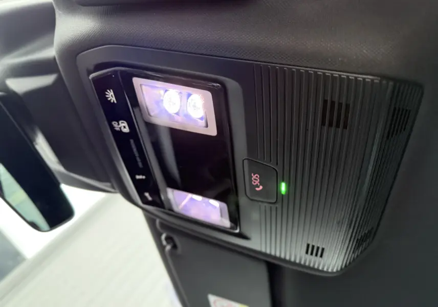 Plafonnier intérieur avec éclairage LED et bouton SOS allumé dans une CUPRA Formentor noir minuit, vue en légère contre-plongée.