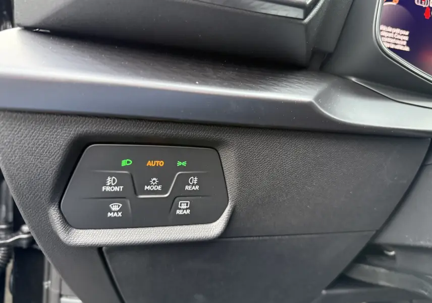 Gros plan sur les commandes d’éclairage et dégivrage côté gauche du tableau de bord d’un CUPRA Formentor noir minuit 2025.