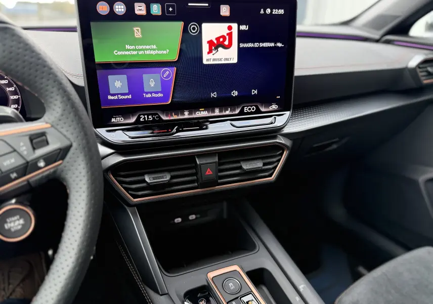 Vue intérieure centrée sur l’écran tactile et la console centrale du CUPRA Formentor 1.5 eHybrid noir minuit, avec détails cuivrés.