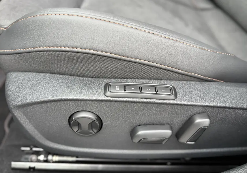 Détail des commandes de réglage électrique du siège avant avec surpiqûres contrastantes dans une CUPRA Formentor noir minuit.