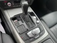 Gros plan sur la console centrale de l'Audi A6 Avant gris métal 2018, montrant le levier de vitesse automatique et les commandes S-Line.