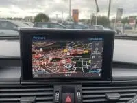 Vue intérieure centrée sur l'écran de navigation du tableau de bord d'une Audi A6 Avant gris métal de 2018.